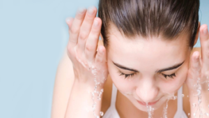 Ženska z mozolji si umiva obraz